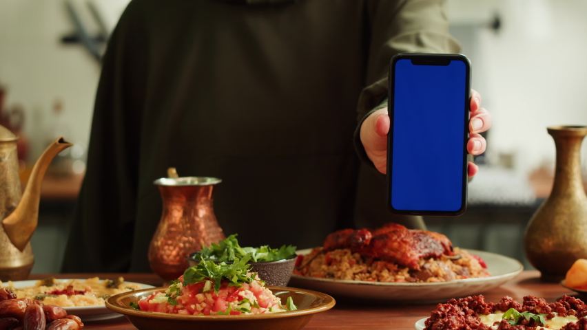 Kabsa, hummus, maqluba, maqluba, tabbouleh close-up, smartphone with blue chroma key screen, middle eastern national traditional food. Muslim family dinner, Ramadan, iftar. Arabian cuisine. | Shutterstock HD Video #1094737123