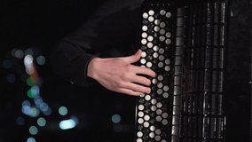 small pan close up of musician playing accordion on beautiful night city lights - Powered by Shutterstock - Get 15% off with code: PIKWIZARD15