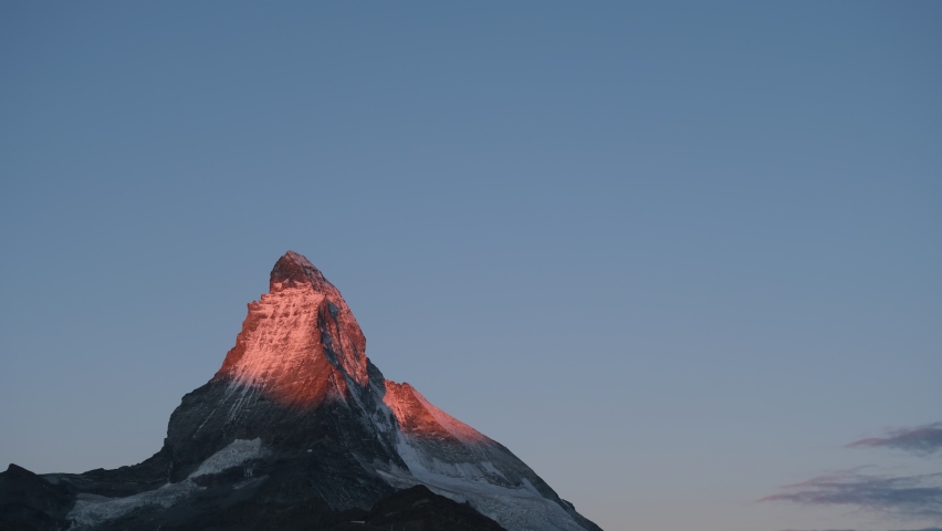 4K time lapse of sun rise that shading on the peak of Matterhorn mountain at Zermatt, Switzerland. with clear blue sky during summer that starting to getting into winter season.  | Shutterstock HD Video #1094739579