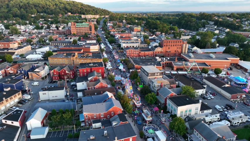 Lancaster County Pennsylvania, USA. Aerial establishing shot of street fair in America. Beautiful golden hour light. Royalty-Free Stock Footage #1094740329