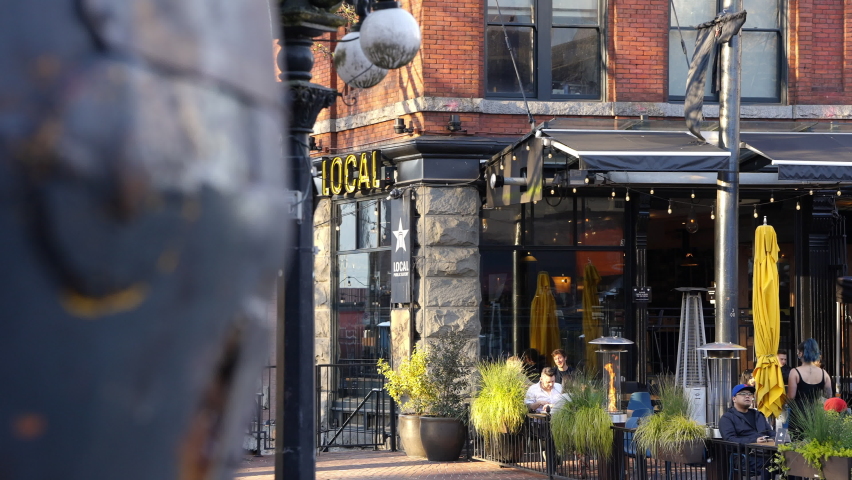 A bustling restaurant in an urban neighborhood during sunset