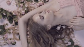 Young Woman Lies In Roses. Delicate scarlet roses and a woman. Aromatherapy. Natural and organic cosmetics, skin care, shampoo. Natural make-up. Gentle perfume. Clean skin - Powered by Shutterstock - Get 15% off with code: PIKWIZARD15