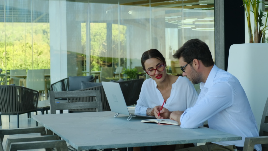 Working together on project. Two young business colleagues working on computer. a businessman in a white shirt and a businesswoman with red lipstick are discussing . business people working together | Shutterstock HD Video #1094749267