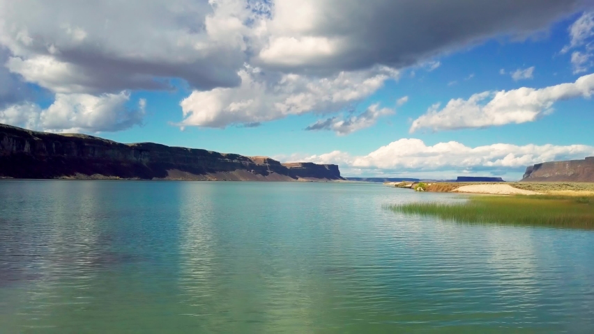 4K ascending drone aerial shot of blue waters of Banks Lake and steep cliffs and grass flats of Columbia Plateau, Washington, United States of America