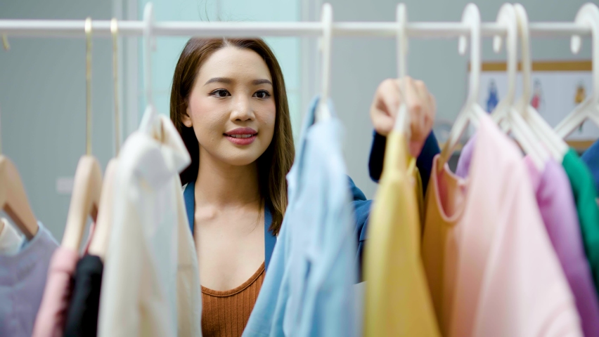 Beautiful woman business owner at fashion store choose clothes in the clothes rail, Fashion designer standing in order to repair, service for customers. Concept Profession Dressmaker designer | Shutterstock HD Video #1094752149