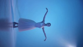 Young beautiful woman, female ballet dancer in white dress on pointe doing elements of classical ballet. Looks tender and graceful. Concept of art, beauty, music and elegance in movements