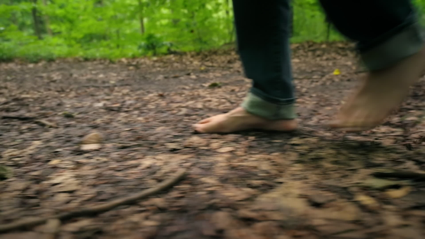 Barefoot walk on forest ground, a closeup shot with the camera smoothly moving around the feet of a hiking man connecting with nature
 Royalty-Free Stock Footage #1094758421