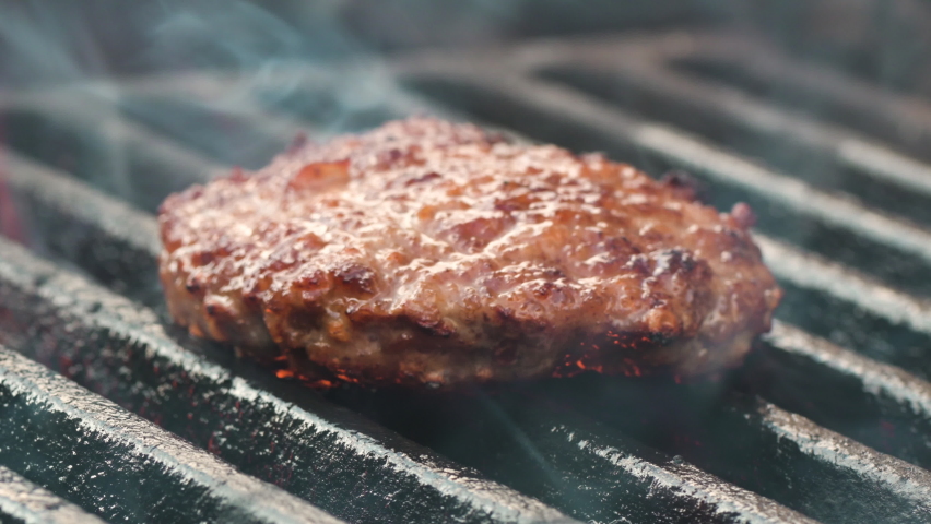 Meat for burger on grill and fire. fry burger meat. slow motion, close-up. Picnic outside meat is grilled outdoors in flame. Barbecue grill. Juicy meat patty is cooked on coals for party in nature Royalty-Free Stock Footage #1094760165