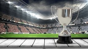 Animation of silver cup in rugby field with camera flashes in sports stadium. sports, winning and competition concept digitally generated video.