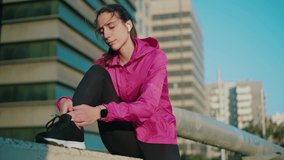 Video of fit and sporty young woman doing stretching in the street at the city.