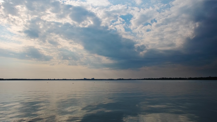 Beautiful reflexion on a lake of a cloudy sky during a sunset. Blue sky with some clouds during a sunset.