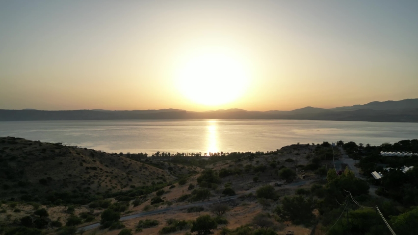 sea of galilee Sunset. Beautiful drone shot of lake Kinneret in the golan heights north israel. Amazing yelllow sunset palms island. Orange colors. Holy land where jesus walked on the water