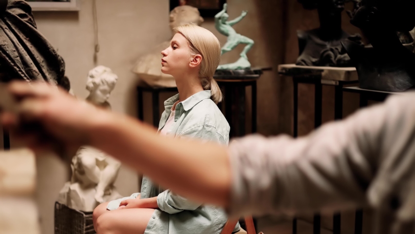 Portrait of attractive blonde woman sitting as a model in sculpture art studio while young sculptor create her beautiful portrait. Inspiration. Art. | Shutterstock HD Video #1094774553