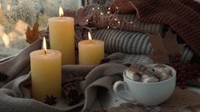 Thanksgiving and Hello Fall, celebrating autumn holidays at cozy home on the windowsill Hygge atmosphere Autumn leaves, spices and candle on cozy knitted sweater in warm yellow lights. Raining Outside - Powered by Shutterstock - Get 15% off with code: PIKWIZARD15
