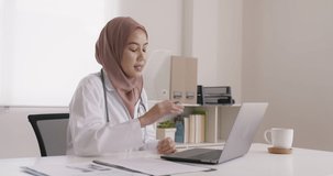 Islam arab GP video call talk share on telemedicine telehealth teleconsult clinic platform app at office desk. Young medic health care worker work for asia people tele consult on online remote visit.
