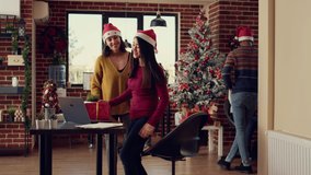 Colleagues giving presents to celebrate christmas eve at work, celebrating winter holiday in office with xmas tree and decorations. Diverse women exchanging gifts during festive season. - Powered by Shutterstock - Get 15% off with code: PIKWIZARD15