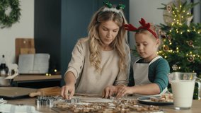 Caucasian woman with daughter making cookies in Christmas time in the kitchen. Shot with RED helium camera in 8K.    
