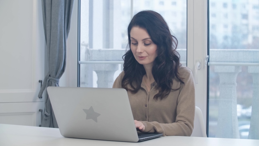 White woman working on laptop at home. Freelancer female person doing distant work on notebook computer | Shutterstock HD Video #1094792861