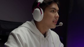 Young streamer streaming game video playing online game on computer at home, Gamer wearing headsets taking on microphone with teammates, Gamer lifestyle, E-Sport online gaming technology