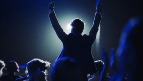 Young Excited Man Ecstatic About Winning the Coveted Business Person of the Year Award. Man Jumping After Winning the Event Category. Handsome Specialist Celebrating and Cheering a Colleague on Stage. - Powered by Shutterstock - Get 15% off with code: PIKWIZARD15