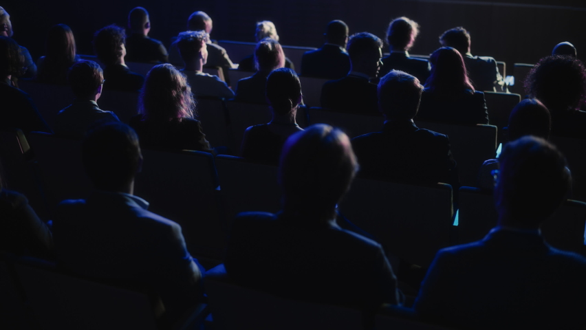 Audience Full of Business People Clapping in Dark Conference Hall During an Inspiring Keynote Presentation. Business Technology Summit Auditorium Room Full of Delegates. Slow Motion Footage. | Shutterstock HD Video #1094794963