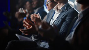 Close Up on Hands of an Audience of People Applauding in Dark Concert Hall During a Business Conference Presentation. Technology Summit Auditorium Room Full of Corporate Delegates. - Powered by Shutterstock - Get 15% off with code: PIKWIZARD15