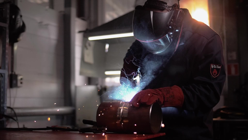 Professional welder works in a dark room with slow motion. Cinematic Royalty-Free Stock Footage #1094797377