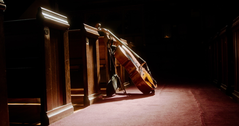 Cello leaning against church pews in the sunlight | Shutterstock HD Video #1094798121