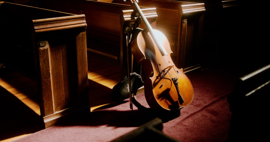 Cello leaning against church pews in the sunlight | Shutterstock HD Video #1094798123