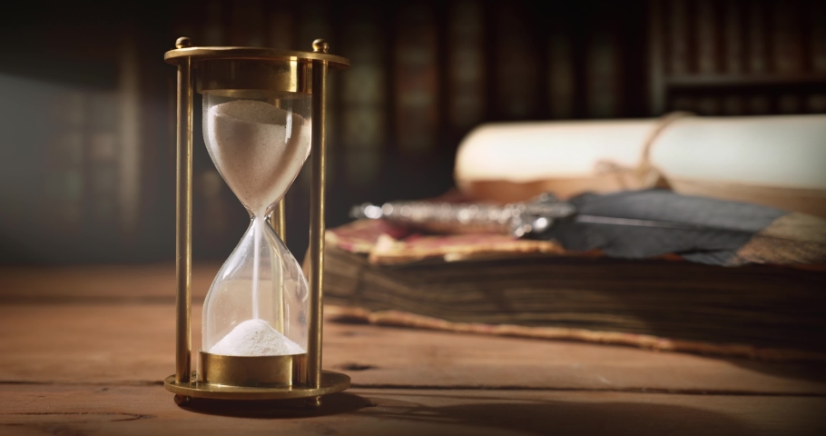 sand running through the hourglass on old wooden table with vintage books and quill pen. time is ticking Royalty-Free Stock Footage #1094800645