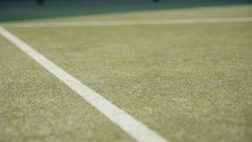 Tennis ball hit the line on grass court. Slow mo video of tennis ball hitting court line.