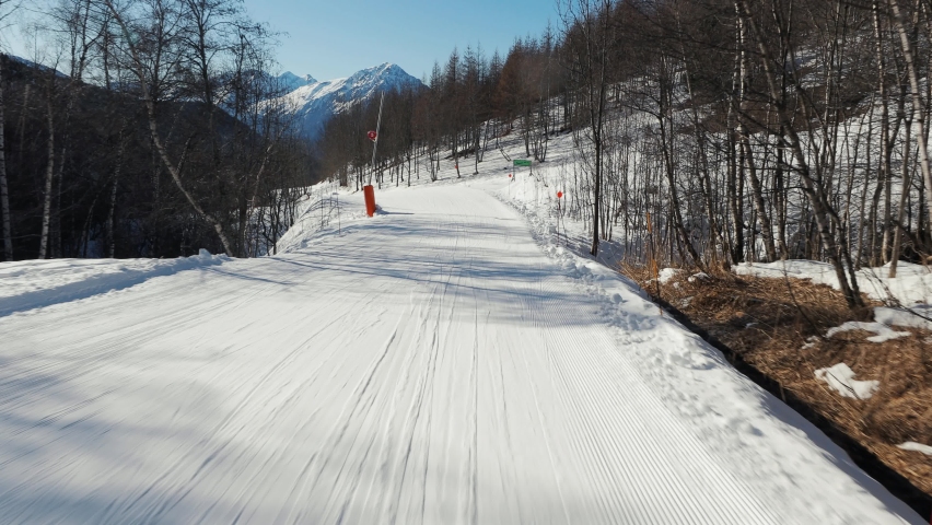 Skiing in the alps, slow, easy slope, realxing ride, forst person point of view, slow motion from 4k 60p footage, sunlight flares
