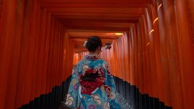 Asian women in traditional japanese kimonos visiting at Fushimi Inari Shrine in Kyoto, Japan.