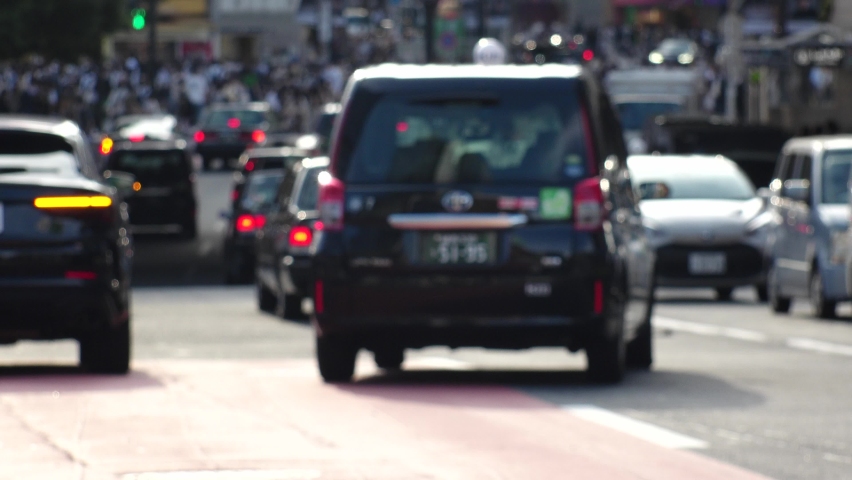 SHIBUYA, TOKYO, JAPAN : Out of focus view of street traffic around Shibuya crossing in busy rush hour. Shot in sunset time. Many cars and taxi at the road. Japanese transportation concept video. Royalty-Free Stock Footage #1094811567