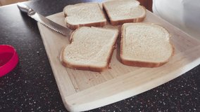 Preparing peanut butter and jelly sandwich on a wood cutting board. - Powered by Shutterstock - Get 15% off with code: PIKWIZARD15