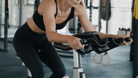Cardio workout on stationery exercise bikes. Close up shot of unrecognizable sporty lady riding on bicycle training apparatus at gym, free space - Powered by Shutterstock - Get 15% off with code: PIKWIZARD15