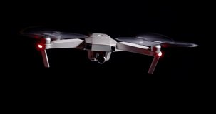 Drone flying hovering agains dark black background, isolated lighting, 4k 60 fps footage