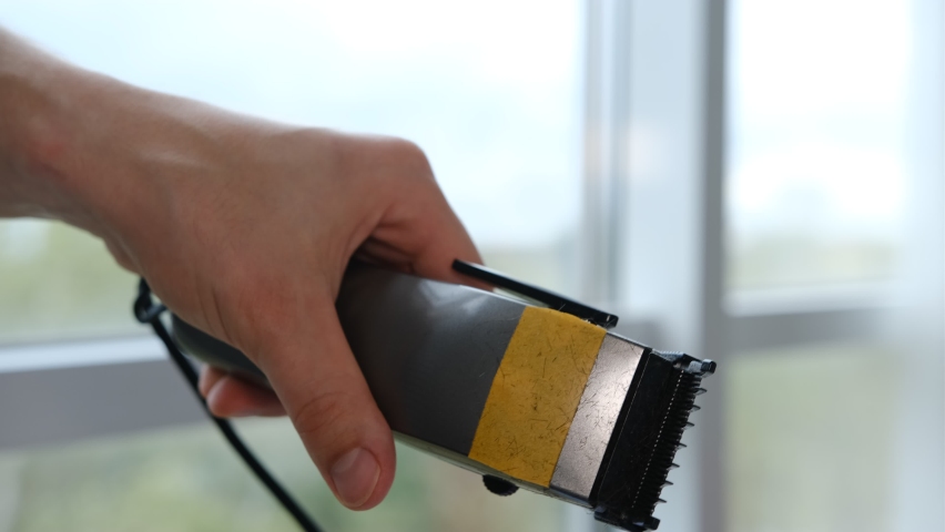A man cleaning a hair clipper with a brush. Royalty-Free Stock Footage #1094831031