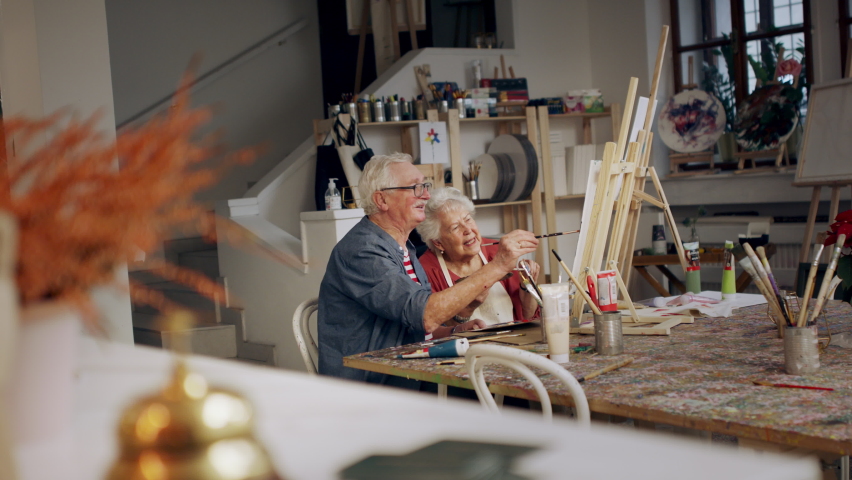 Senior couple painting together in artist atelier.
