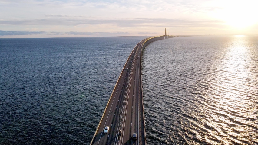 Drone flying over an Oresund bridge at the sunset in summer. Cinematic shot of long tunnel bridge between Sweden and Denmark. Oresund bridge from the top. High quality 4k footage | Shutterstock HD Video #1094837921