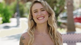 Young blonde woman smiling confident doing kiss gesture with hand at park - Powered by Shutterstock - Get 15% off with code: PIKWIZARD15