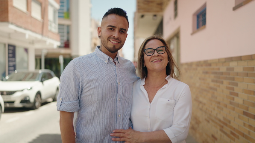 Man and woman mother and daugther hugging each other at street