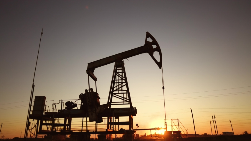 oil production. silhouette oil and gas production rig at sunset glare. oilfield business a extraction concept. oil extraction pump lifestyle. Oil pump rig Royalty-Free Stock Footage #1094839535