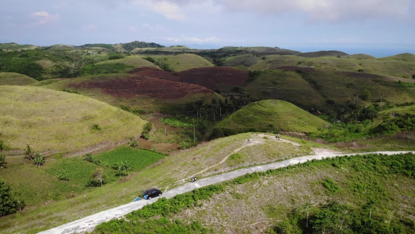 Aerial HD drone footage of woman wondered by little hill formations on top of Nusa Penida Island, Bali, Indonesia.
Parallax movement, mid angle.