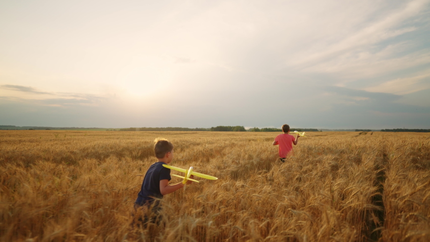 Happy little boys are running in golden rule field, playing with toy planes, calm and peaceful life | Shutterstock HD Video #1094854129