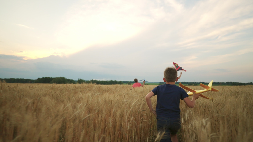Farmers children playing in golden rye field in summer, following rear view, little boys running through ears | Shutterstock HD Video #1094854135