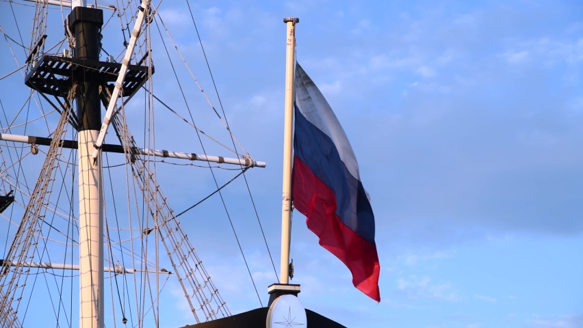 Russian national flag on the stern of sailing ship swings in the wind against blue sky. Close-up view. Real time video. Travel in Russia theme. | Shutterstock HD Video #1094859547