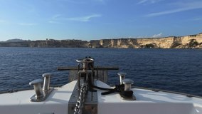 First person view of bow of sailing boat moving forward navigating toward Bonifacio city on top of high cliffs in Corsica, France. 50fps fpv and sky for copy space