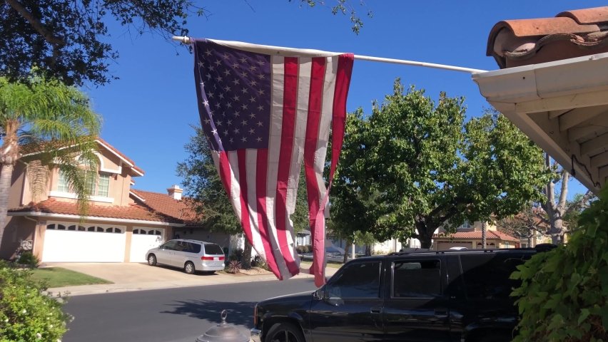 Ventura County CA USA Sept 25 2022 House flying a tattered American Flag to support patriotism and freedom Make America great again Proud citizen flying the red white blue on a sunny california day | Shutterstock HD Video #1094863309