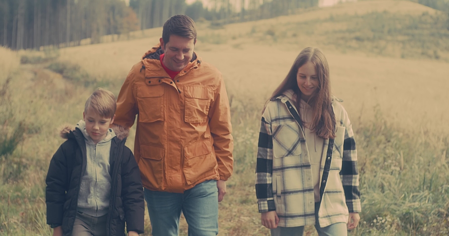 Happy family outdoors while spending his free time, Father and children are happy to walk park, Parents hold the child by the hands. Enjoy time together. Natural colors. | Shutterstock HD Video #1094866325